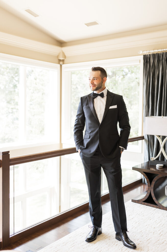 groom standing near indoor balcony 