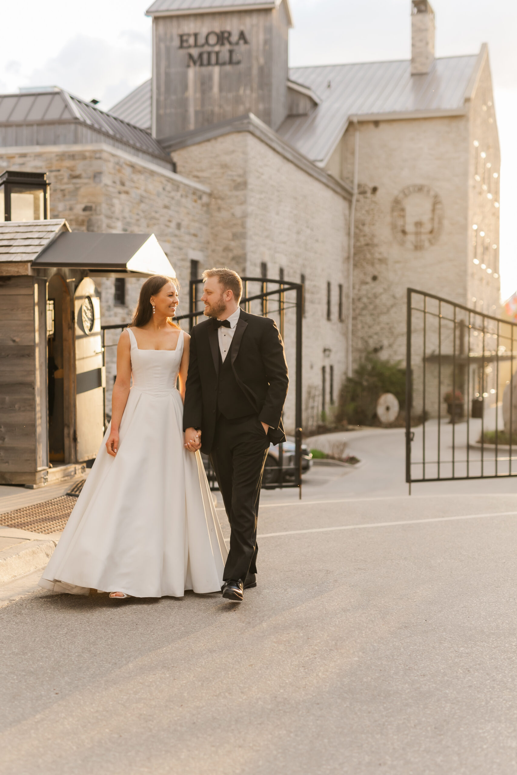 Romantic newlywed portrait in front of historic Elora Mill building.