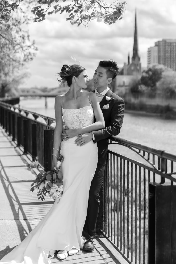 Newlyweds overlooking the Grand River at Cambridge Mill, editorial-style portrait.
