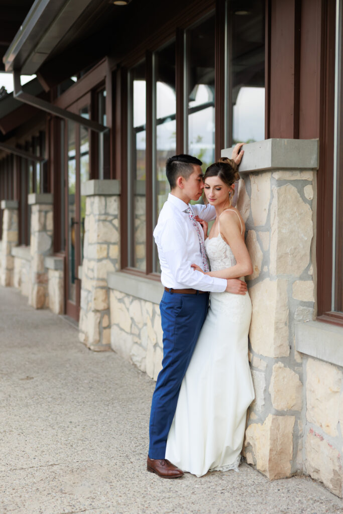 Bride and groom sharing a candid moment on the stone steps at Cambridge Mill.
