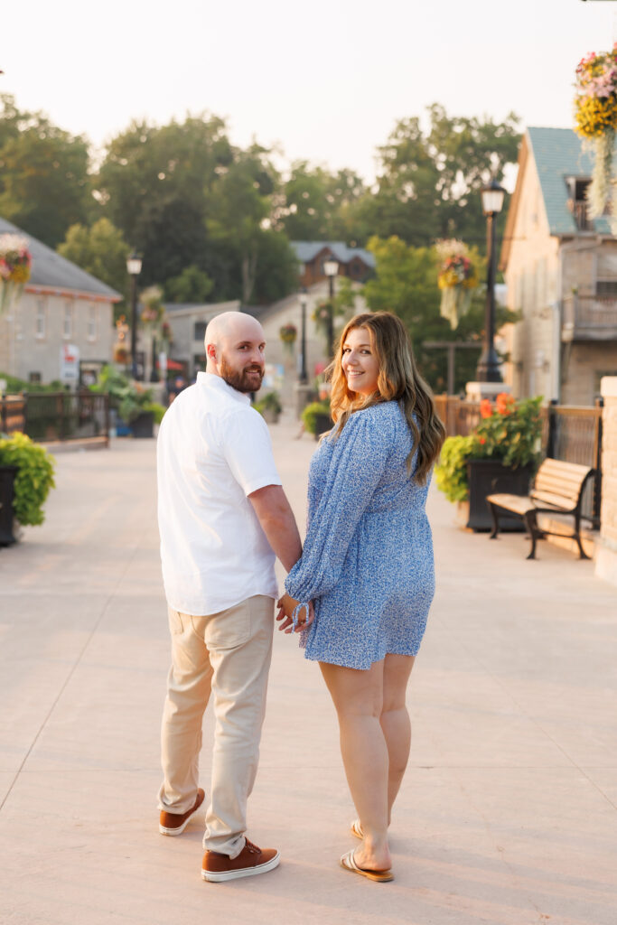 Couple holding hands during engagement session at Elora Mill