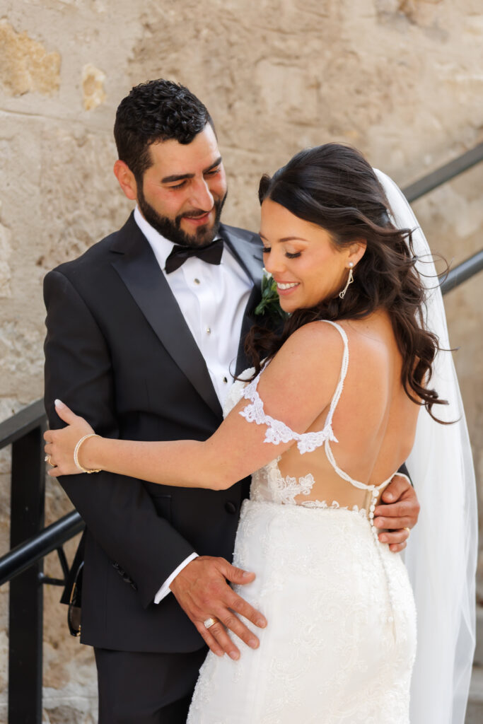Bride and groom on the stone staircase at Tapestry Hall in Cambridge, editorial wedding portrait.