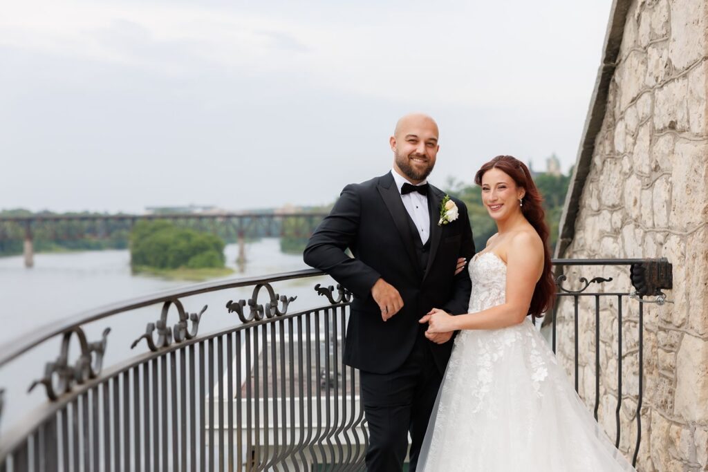 couple over looking the river on the cambridge mill balcony