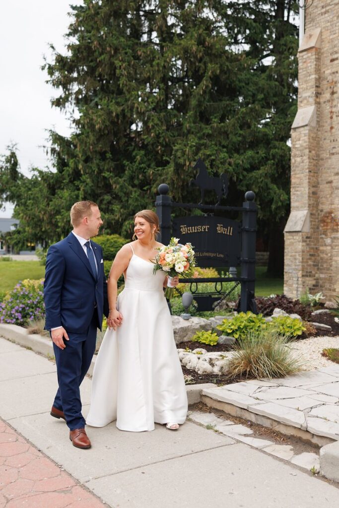 bride and groom walking outside of hause hall wedding 