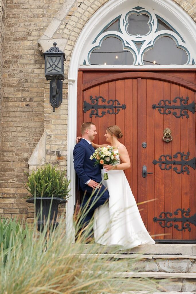 couple standing in front of church doors at hauser hall