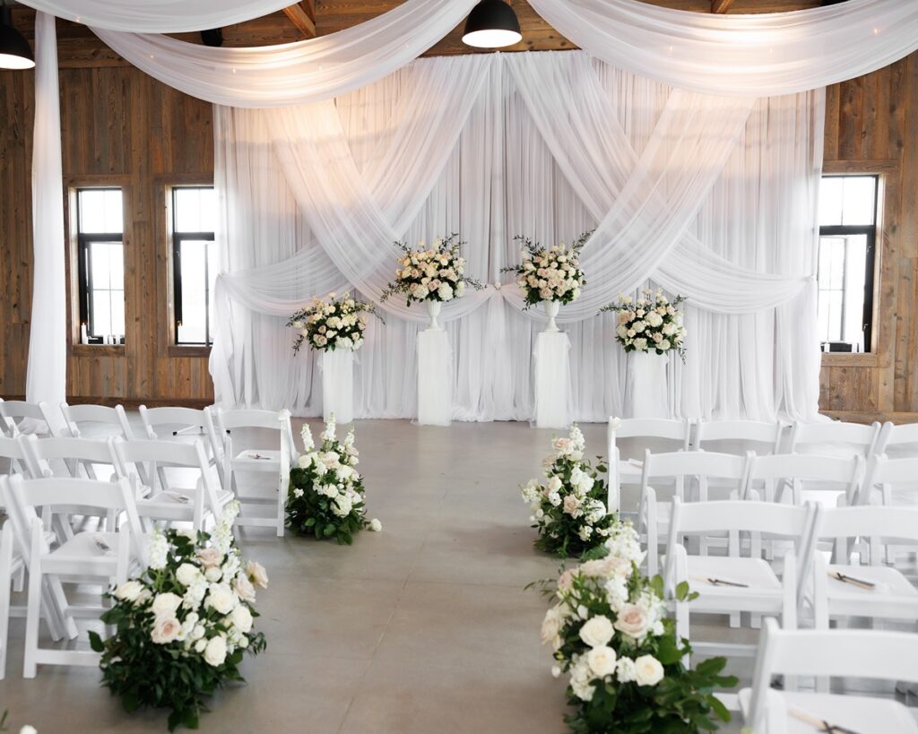 wedding ceremony with white drapes and florals at TPC Osprey Valley pavilion