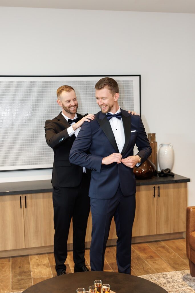 Groom in black tux in modern lounge at TPC Osprey Valley