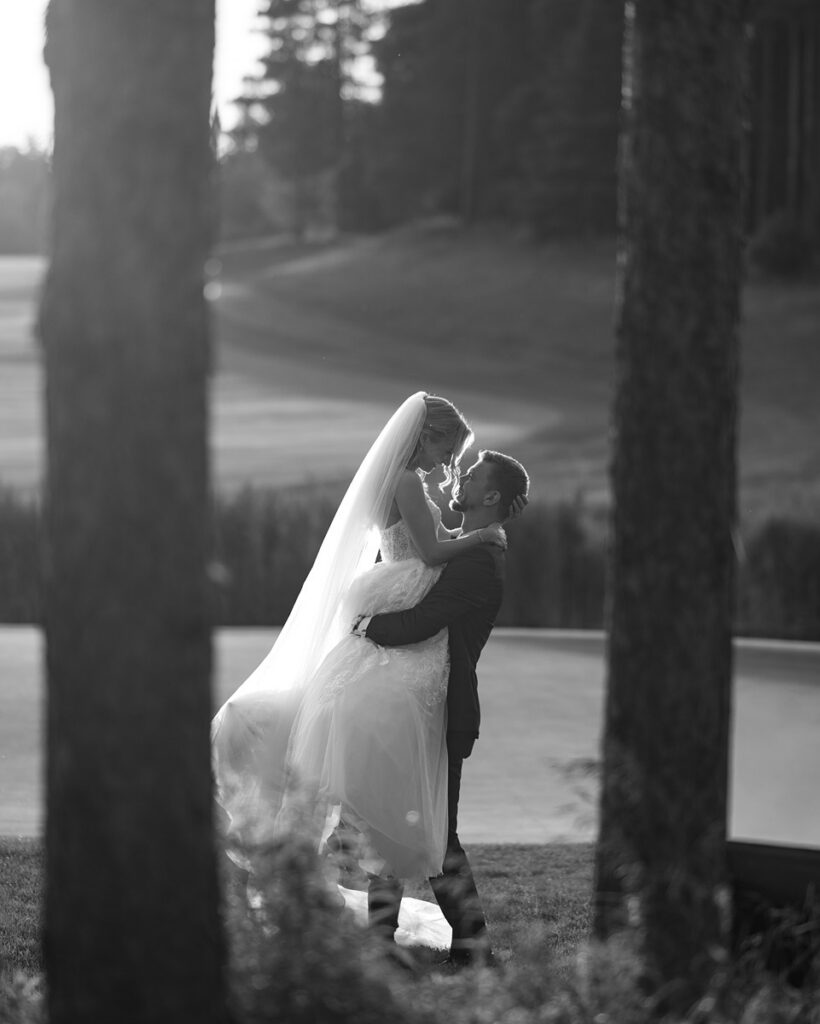 Black and white romantic portrait of bride and groom on golf course grounds